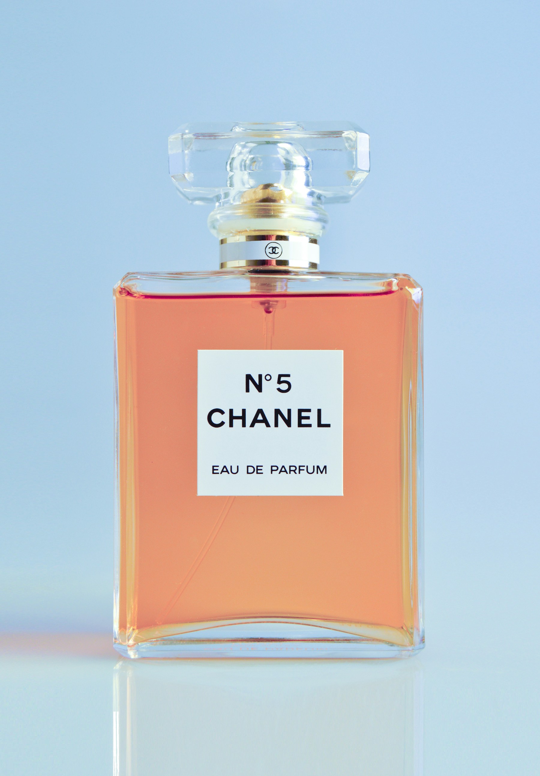 Frasco de perfume fotografiado con luz cálida y fondo oscuro
