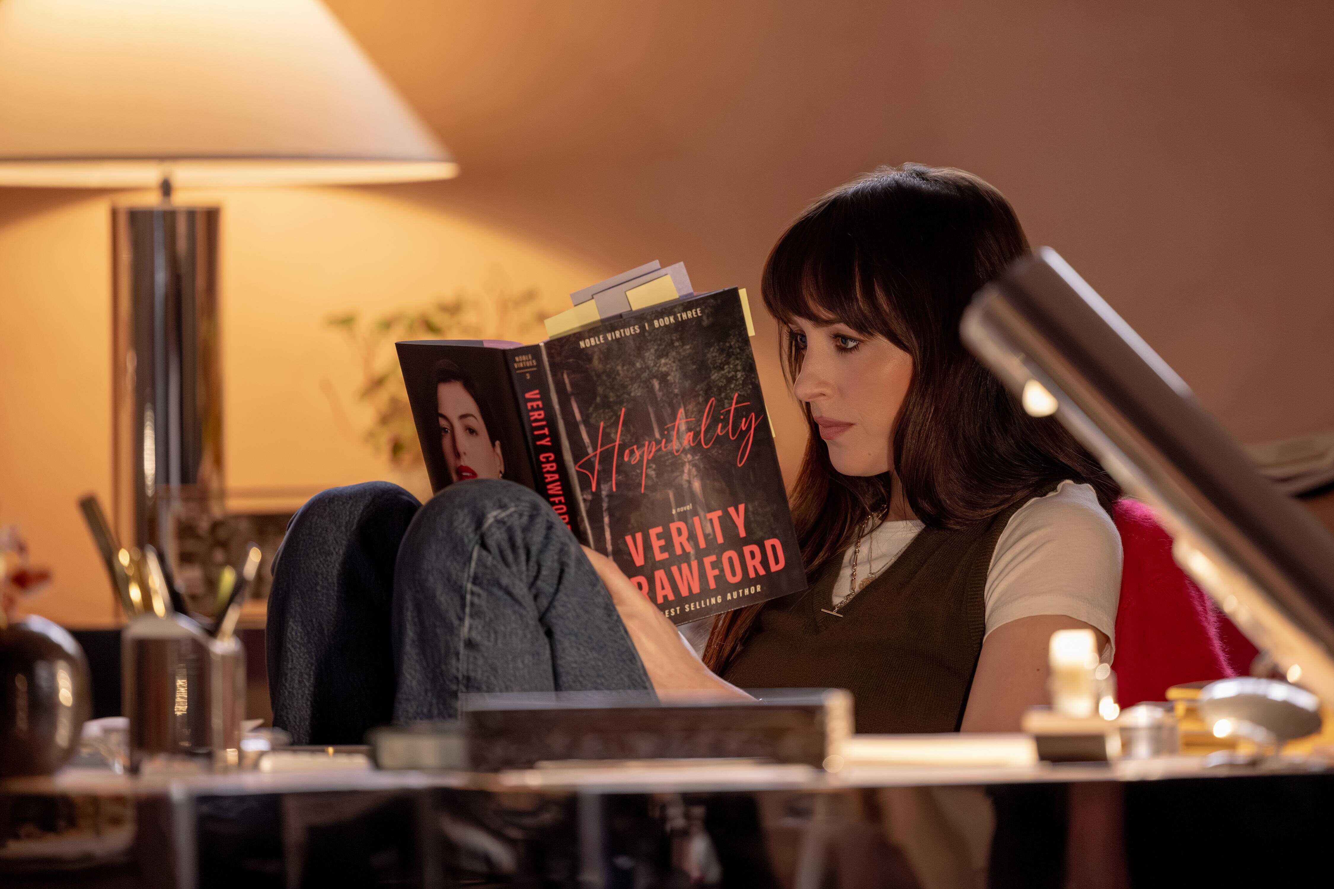 Dakota Johnson como Lowen Ashleigh leyendo un libro de Verity Crawford en Verity